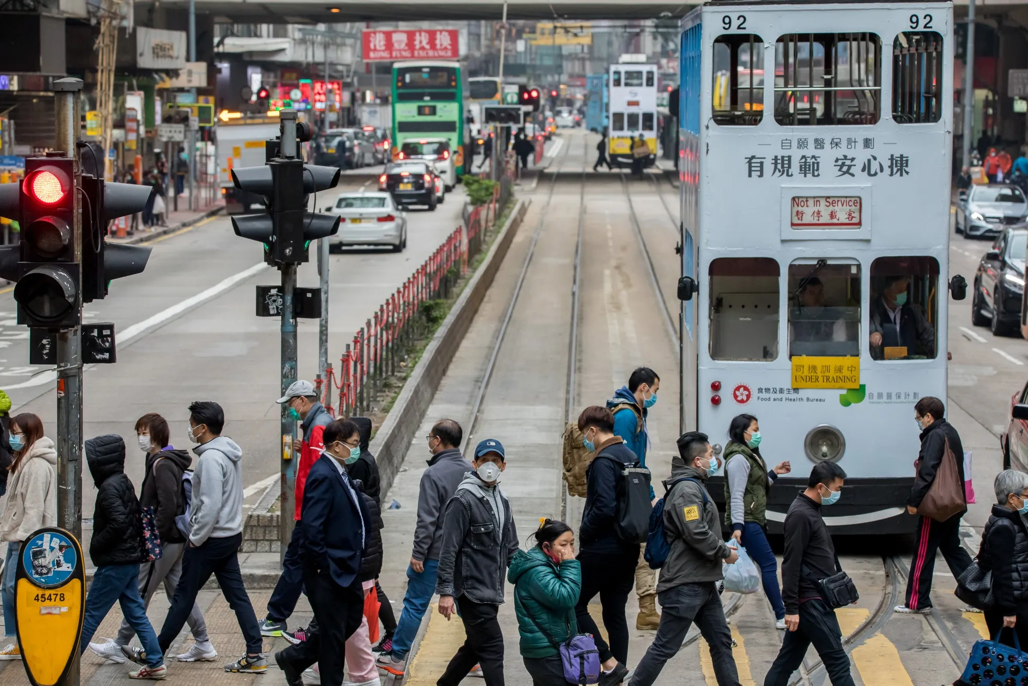 Pedestrians wearing protective masks cross a street on Hong Kong Island.