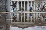 Pedestrians and cyclists pass the U.S. Treasury building in Washington, D.C., U.S.