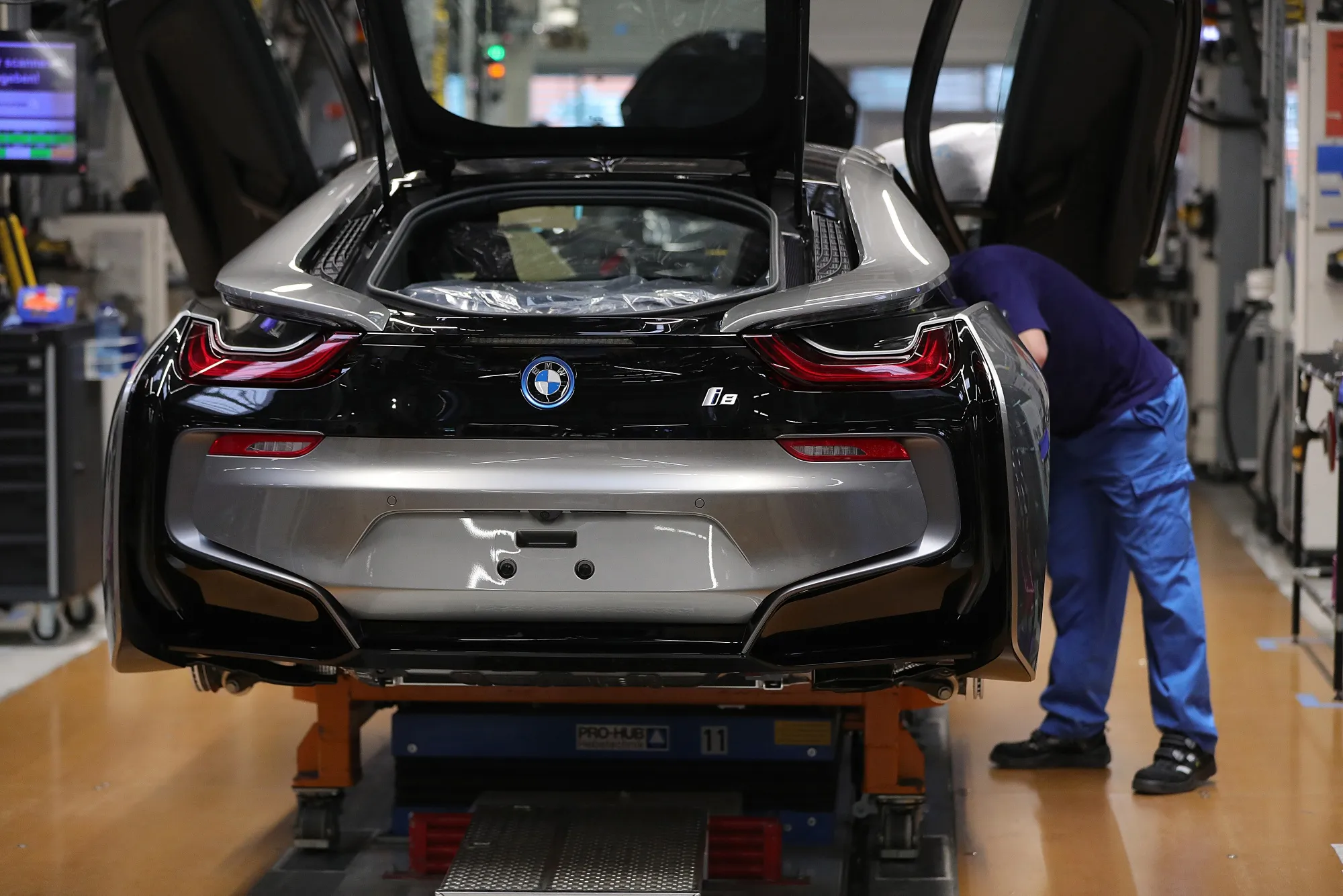 An employee secures a door frame fitting on an automobile at the Bayerische Motoren Werke factory in Leipzig, Germany.