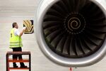 A technician inspects one of the Rolls-Royce engines powering a Singapore Airlines Airbus A340-500