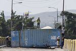 A pro-opposition demonstrator stands on top of a container set up as a barricade during a protest on the Simon Bolivar International Bridge in San Antonio del Tachira, Tachira state, Venezuela on Feb. 25, 2019.