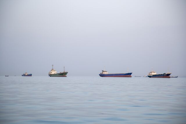 Ships are anchored near the Iranian shoreline in the Strait of Hormuz on April 22, 2026.