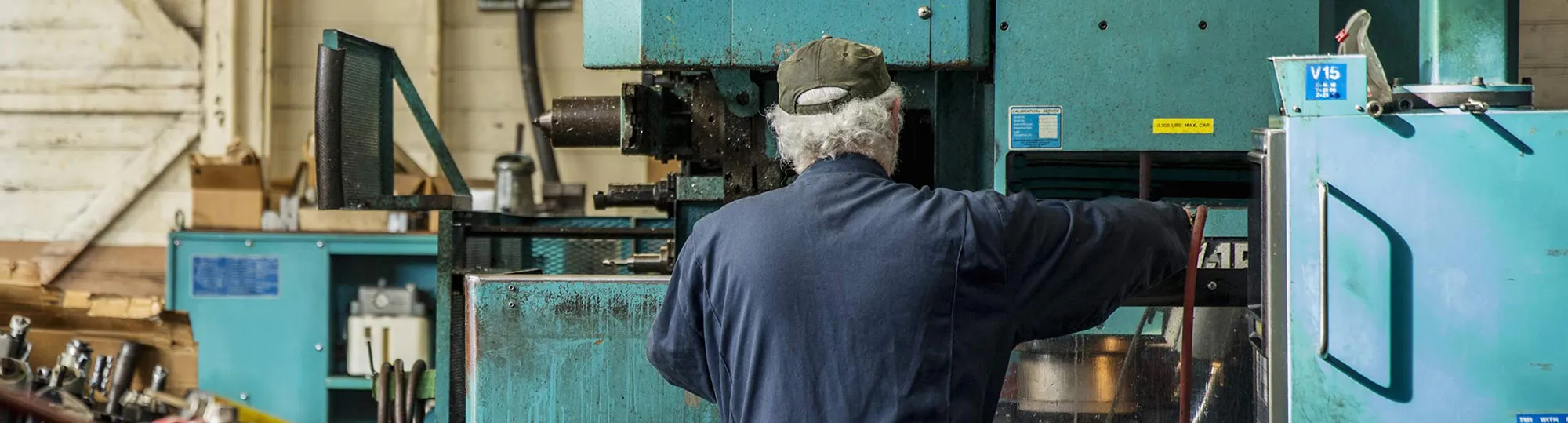 Caucasian man using machinery in metal shop