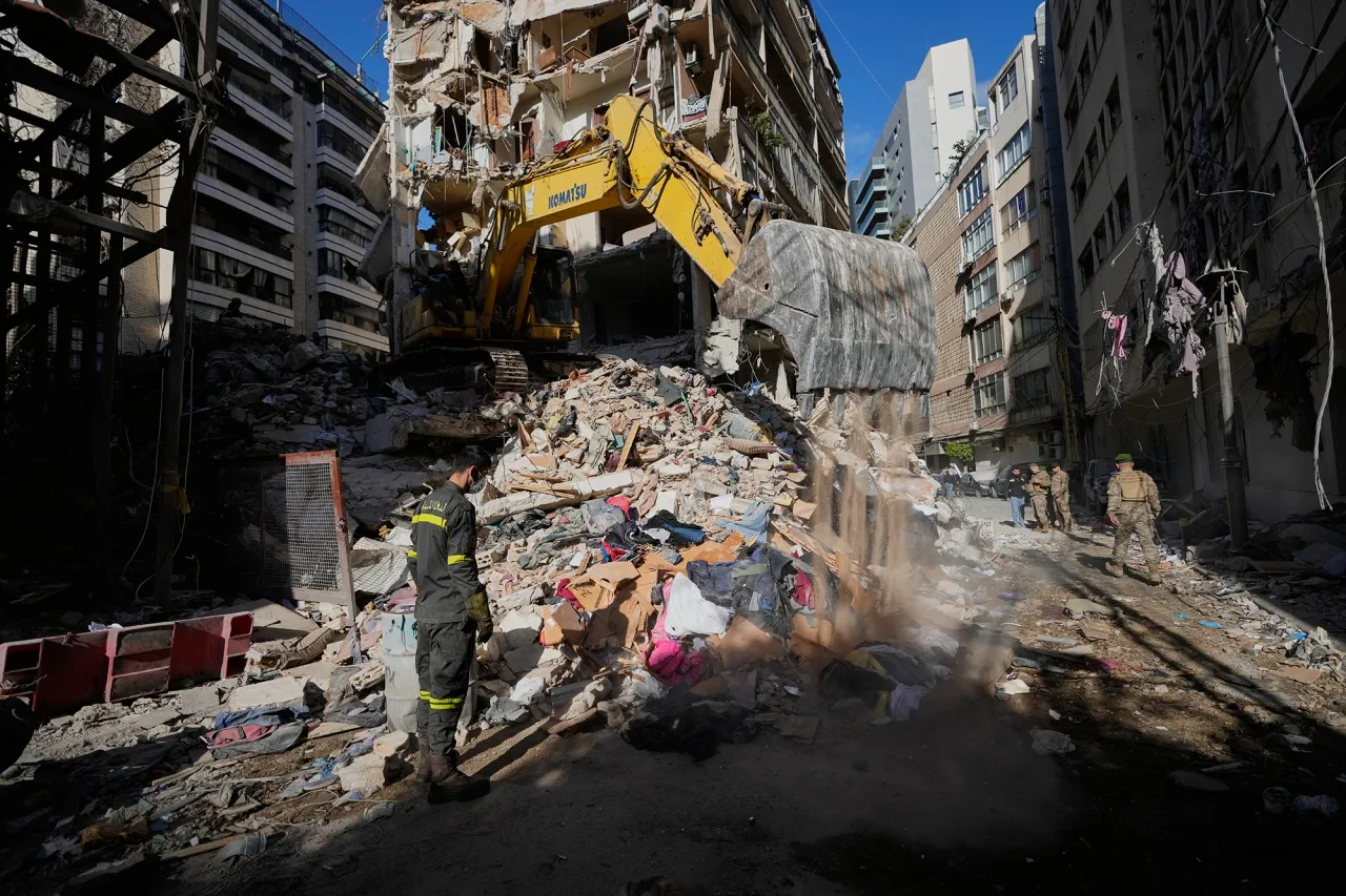 A civil defense worker looks on as an excavator clears the rubble of a building destroyed in an airstrike in Beirut on April 9.