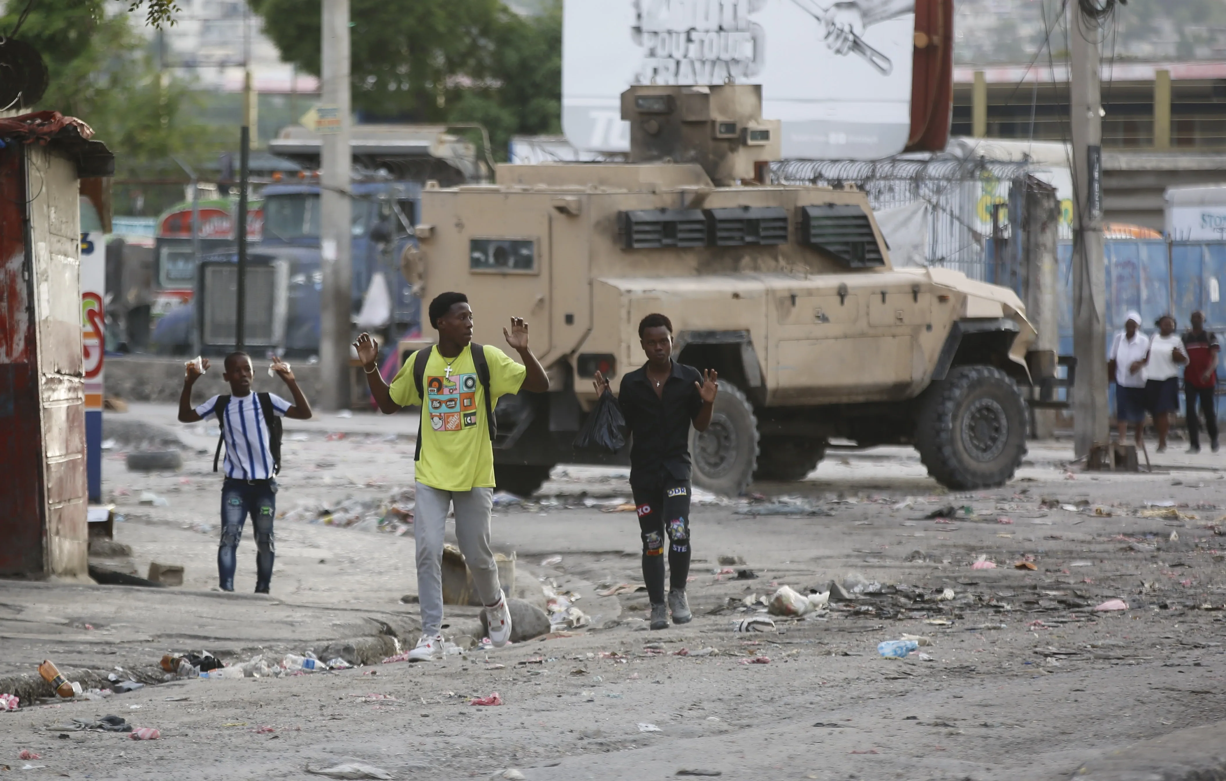 Residents raise their hands to show they are not carrying weapons in Port-au-Prince, Haiti.