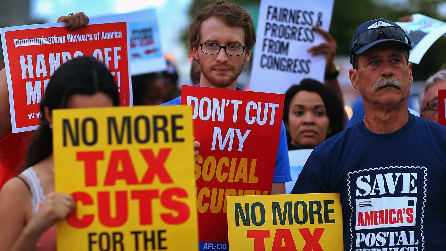Glenn Rehn (C) and Sandy Lleo (R) along with other protesters rally together outside the office of U.S. Sen. Marco Rubio (R-FL) on December 10, 2012 in Doral, Florida.

