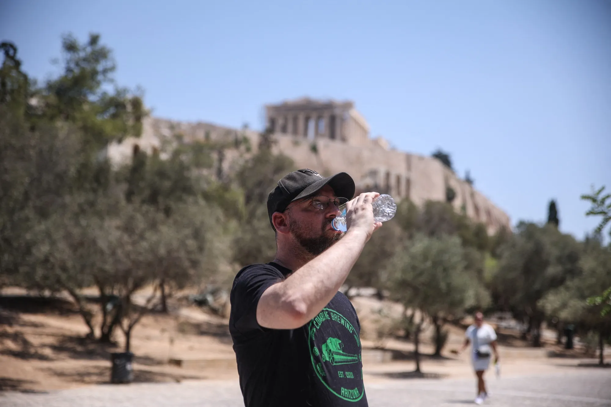 A tourist cools off during high temperatures near The Acropolis in Athens.
