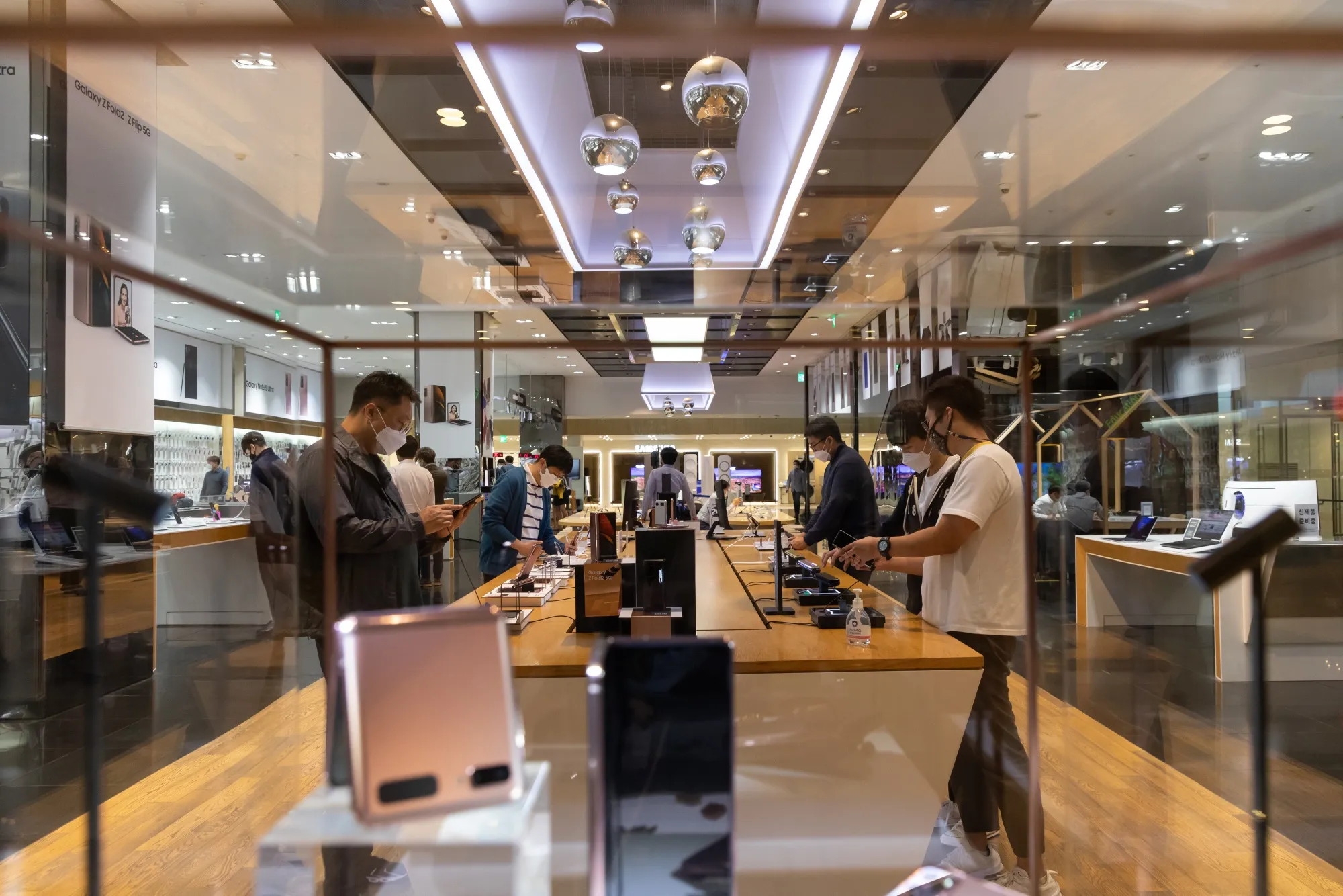 Customers try out Samsung Electronics Co. smartphones at the company's D'light flagship store in Seoul, South Korea, on Oct. 6.