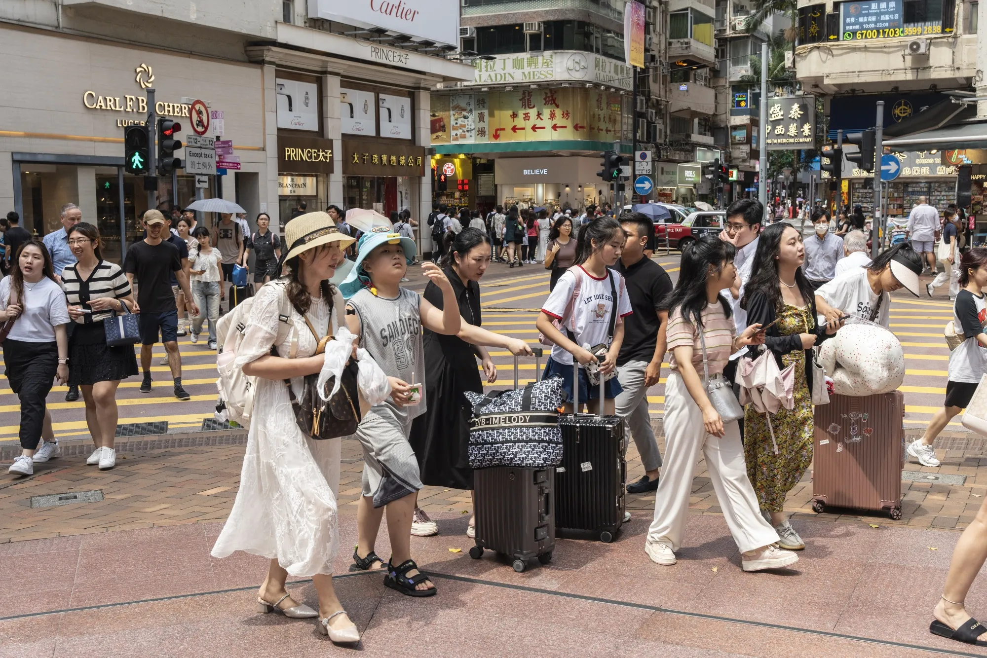 Pedestrians with luggages on Russell Street in the Causeway Bay area.
