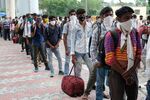 Migrant workers arriving from neighboring states line up as they wait to undergo Covid-19 rapid antigen testing at a temporary facility set up at the Anand Vihar inter-state bus terminal in New Delhi, India, on&nbsp;Aug. 18.