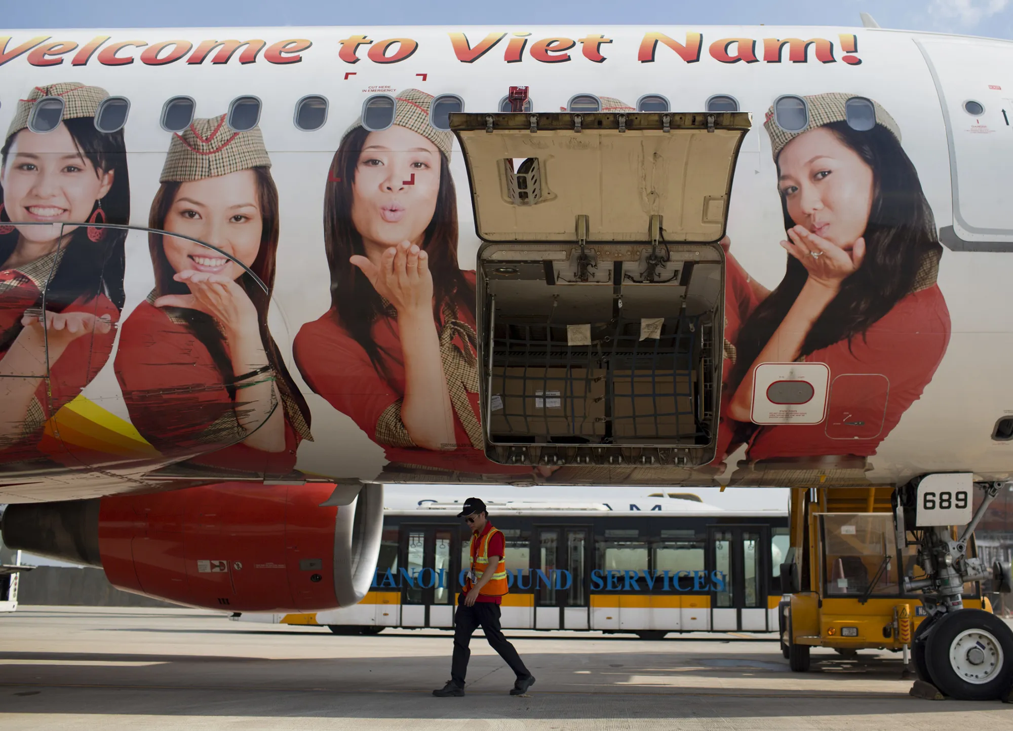 An employee walks under a Vietjet aircraft at Noi Bai International Airport in Hanoi.
