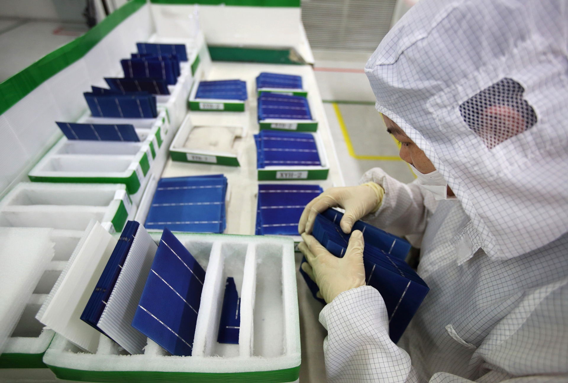 An employee performs a final inspection on solar cells in Changzhou, Jiangsu Province, China.