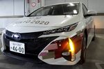 A staff member uses an smartphone app for drivers to unlock a Toyota Motor Corp. Prius plug-in hybrid vehicle (PHV) during a demonstration of the Tokyo 2020 Olympic Games' transport operation support system for personnel in Tokyo, Japan.