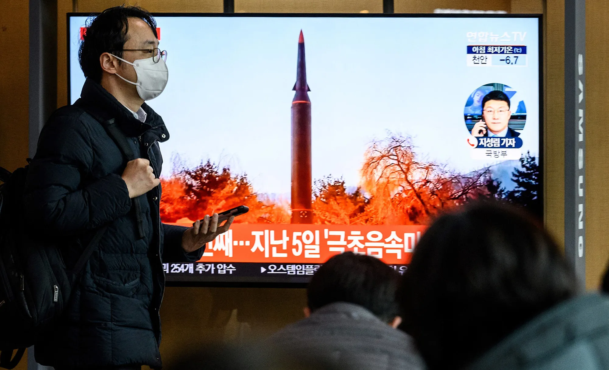 A man walks past a television showing a news broadcast with file footage of a North Korean missile test, at a railway station in Seoul on Jan. 11.