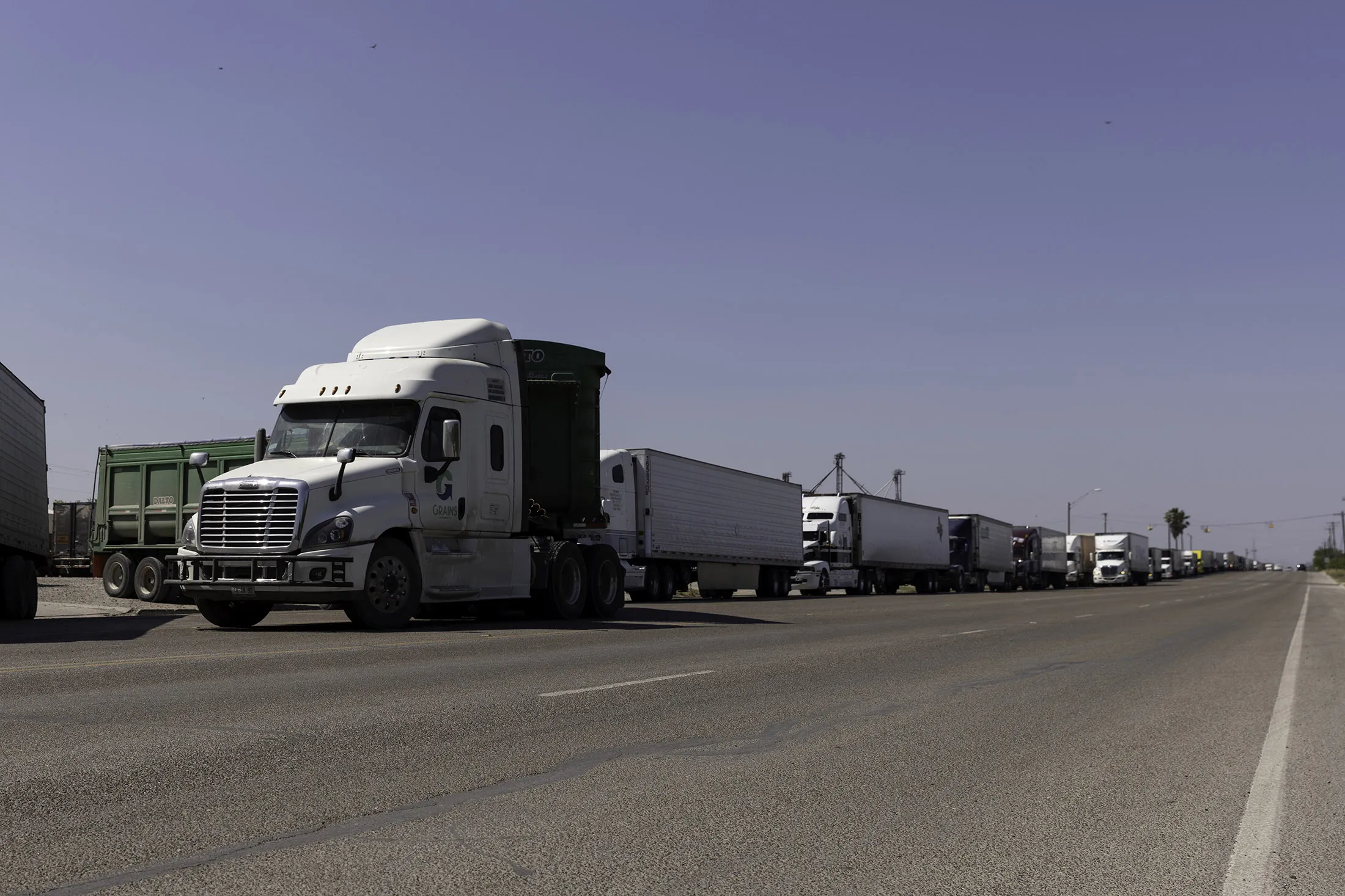 Hundreds of commercial trucks wait in line to cross the Progreso International bridge into Mexico on April 13.