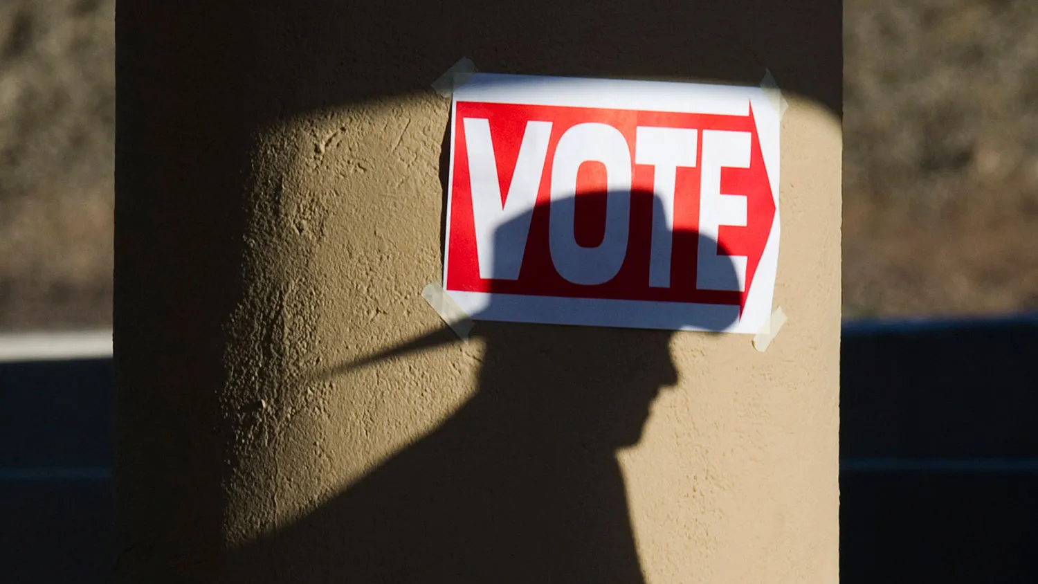 A shadow of a man wearing a cowboy hat falls on a pillar as he enters the polling place at Wickenburg Community Center on Feb. 28, 2012, in Wickenburg, Arizona.
