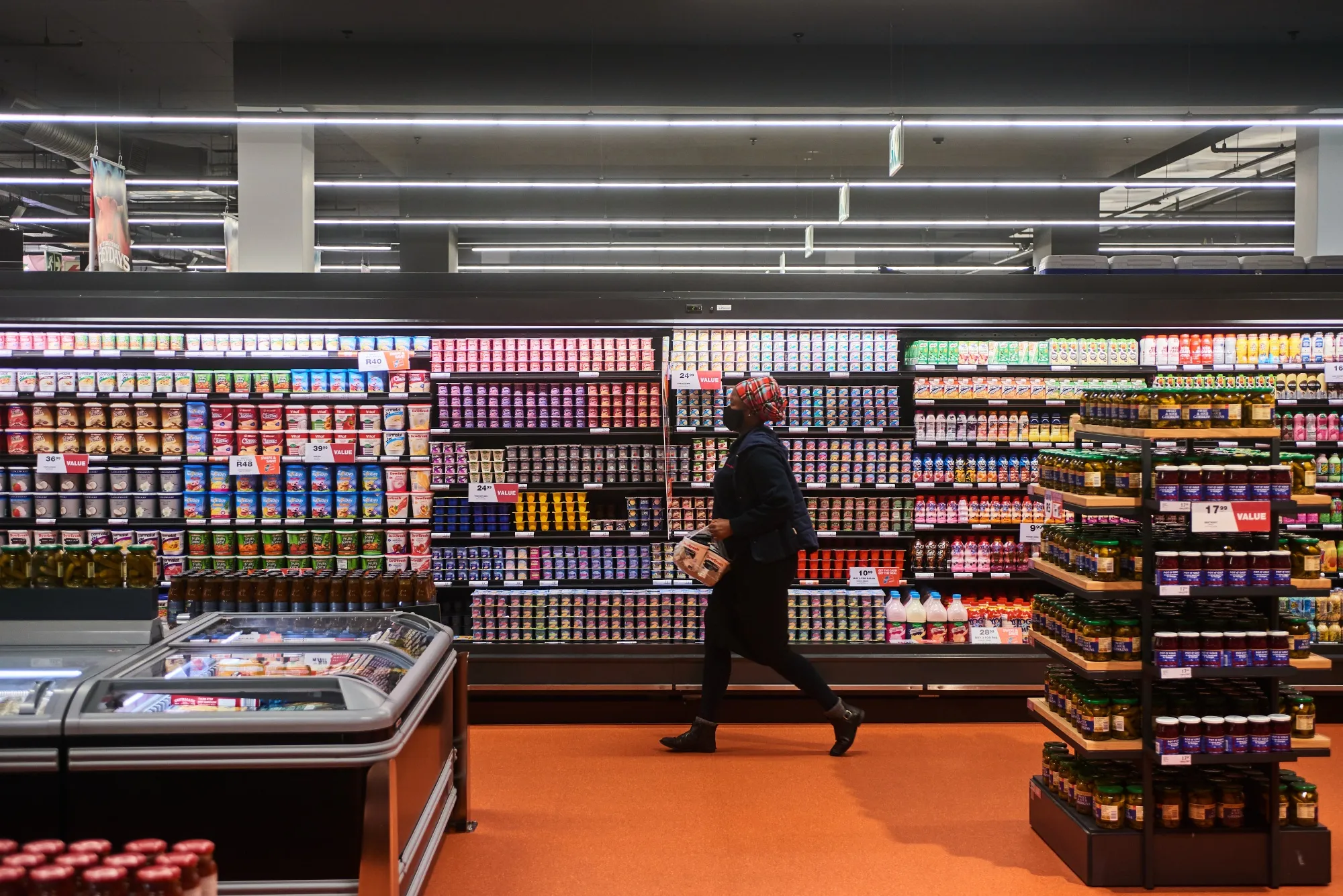 A shopper carries items from the refrigerated dairy shelf inside a supermarket in Johannesburg, South Africa.