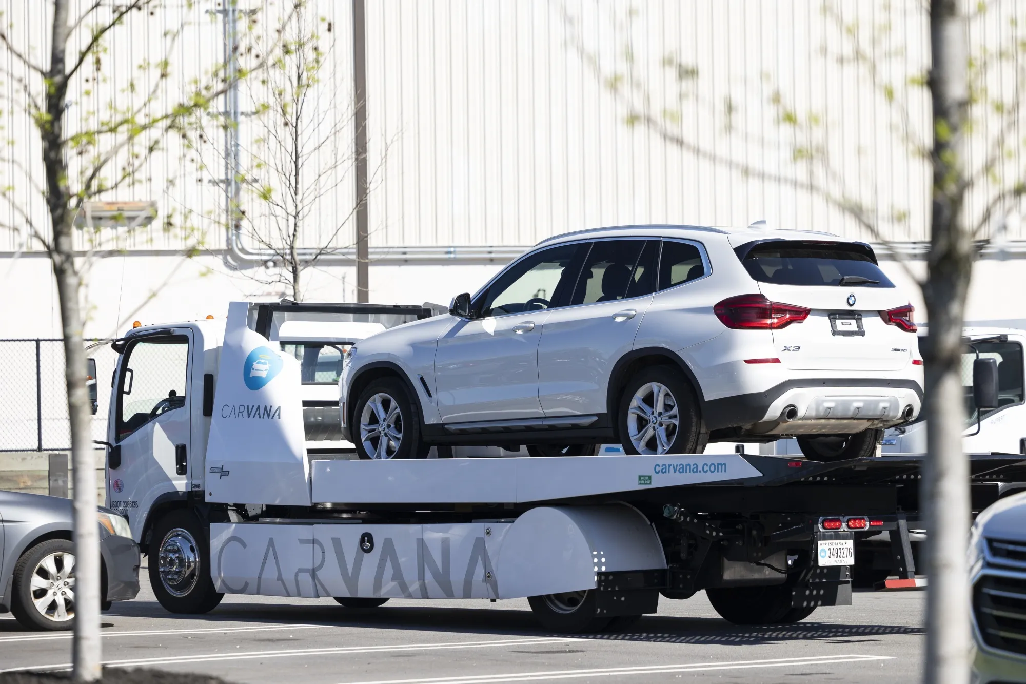 A BMW vehicle on a flatbed truck at a Carvana vending machine location in Uniondale, New York, in 2024.