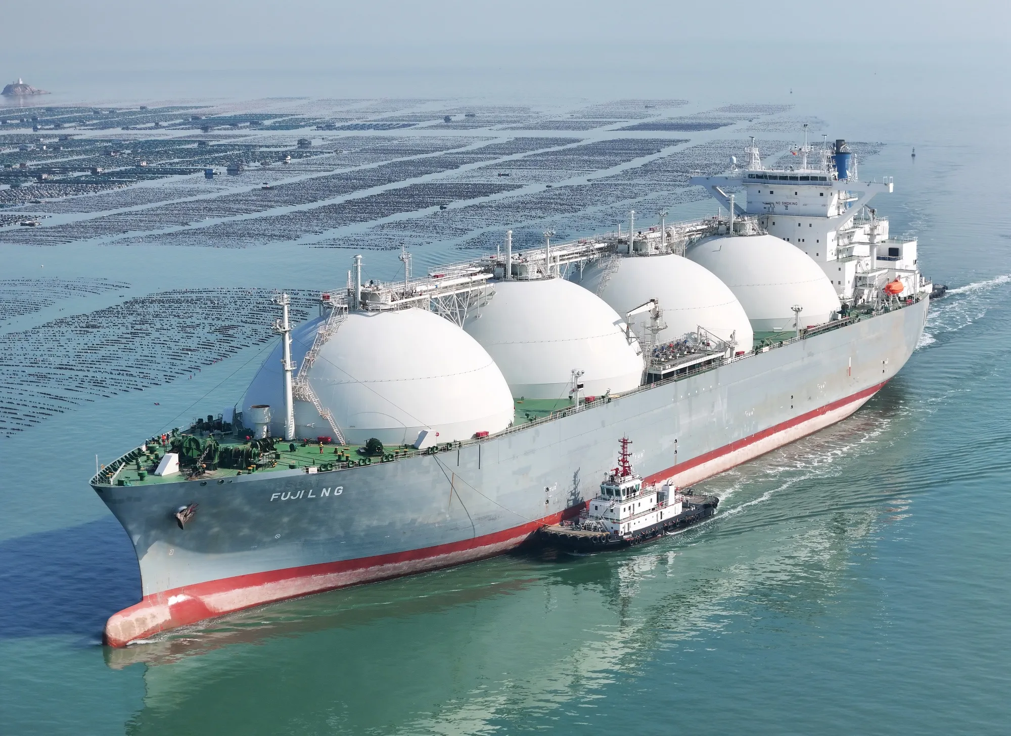 An LNG&nbsp;carrier is assisted by a tugboat as it docks in Shandong province.