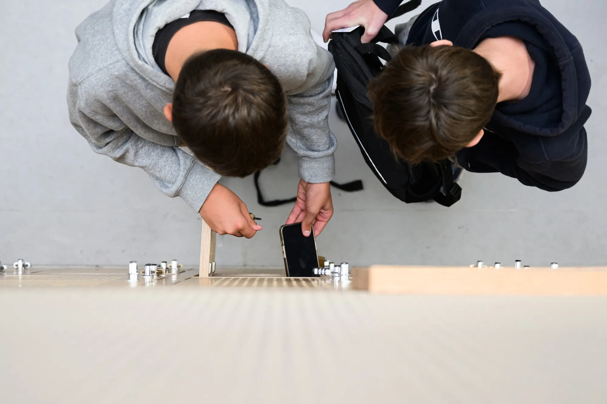 Students place their mobile phones in lockers at a school.