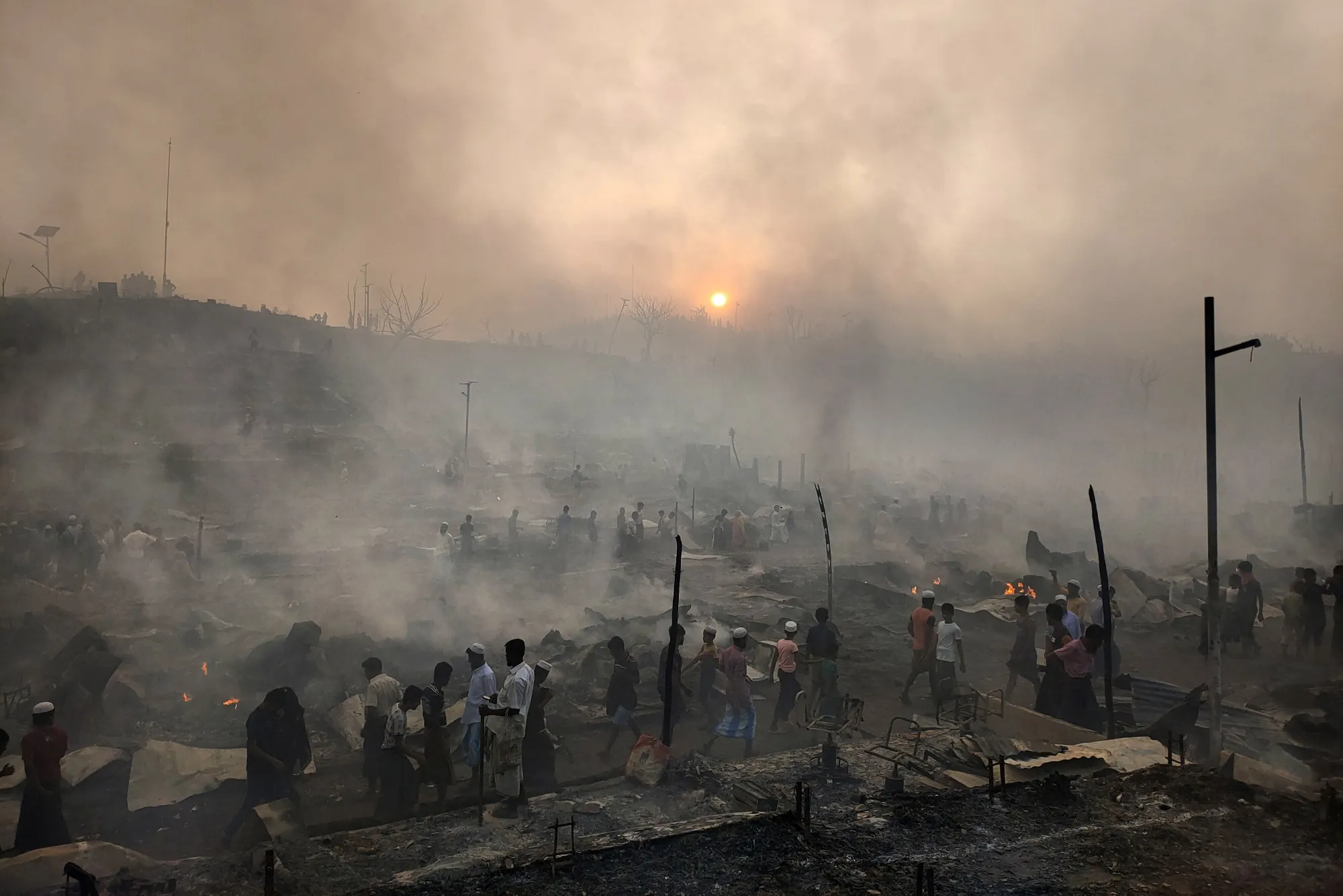 Rohingya refugees try to salvage belongings after a fire at the Balukhali camp in Bangladesh, on March 5.