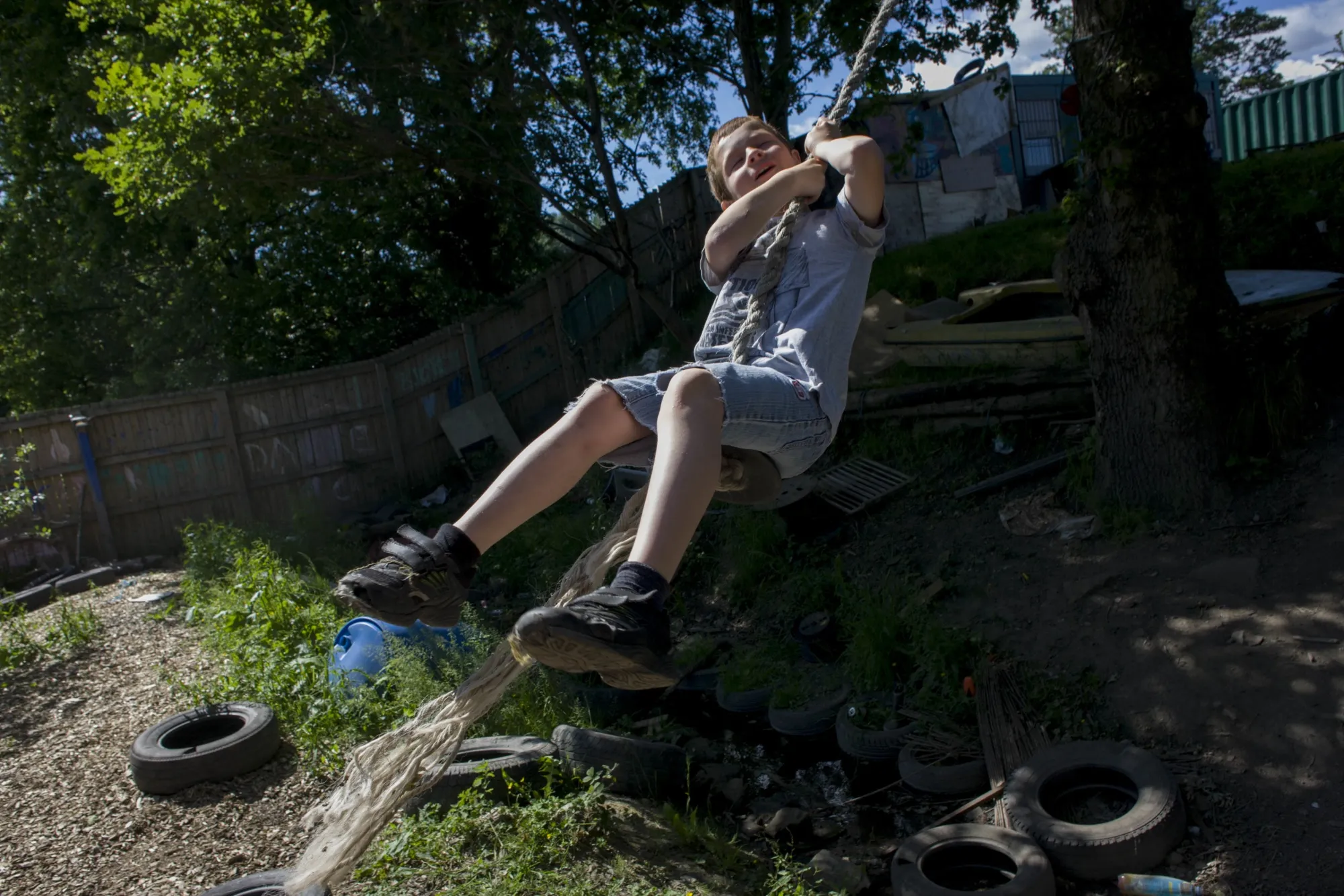 A boy swings on a rope at an “adventure playground” in Wrexham, Wales. At this park, children are encouraged to experiment with unstructured free play&nbsp;using recycled materials like tires and pieces of lumber.&nbsp;