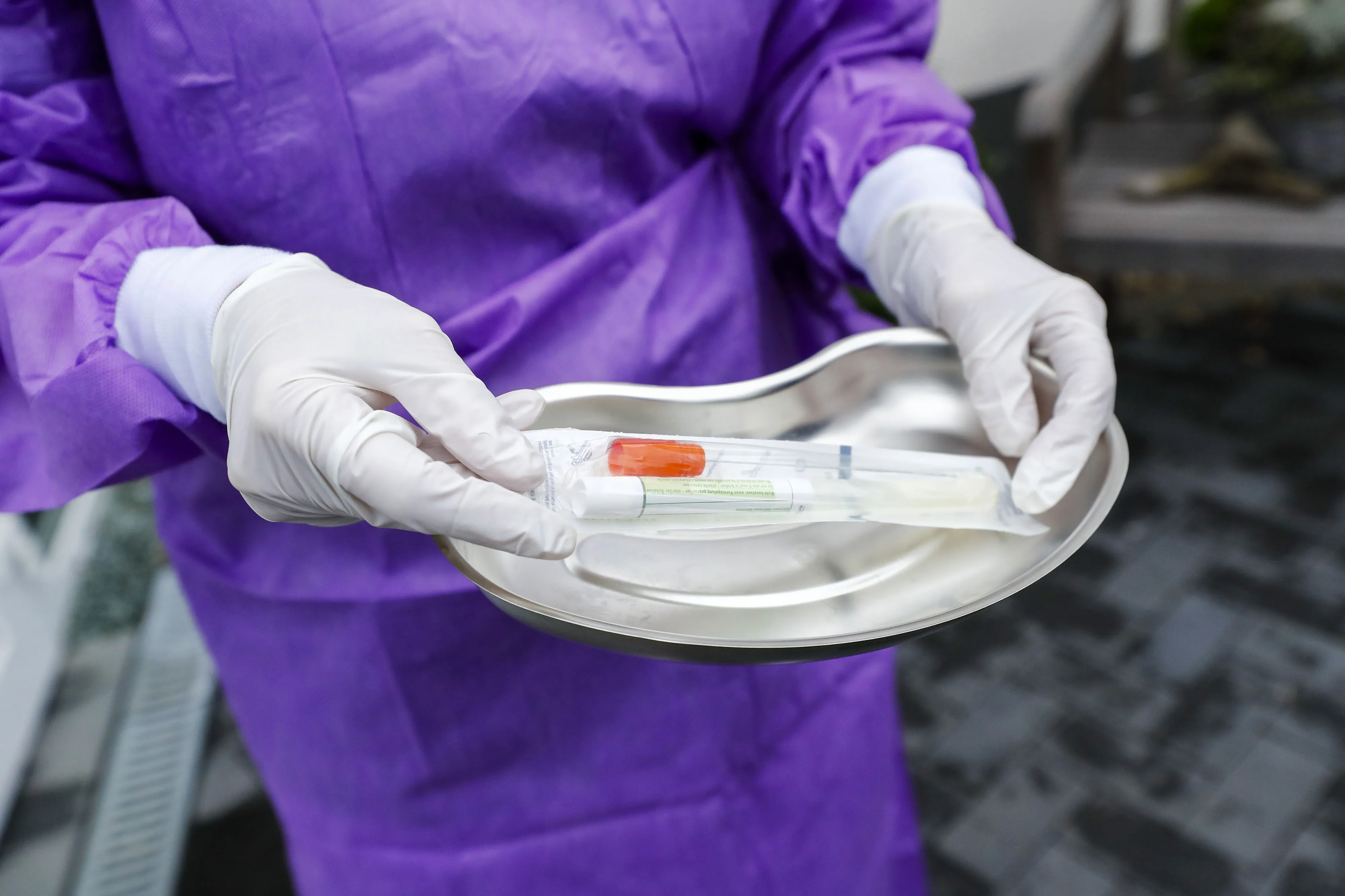 A doctor carries a syringe and swab kit in a kidney dish before carrying out coronavirus testing on a patients at a drive-in clinic at the hospital in Gross Gerau, Germany, on March 9.