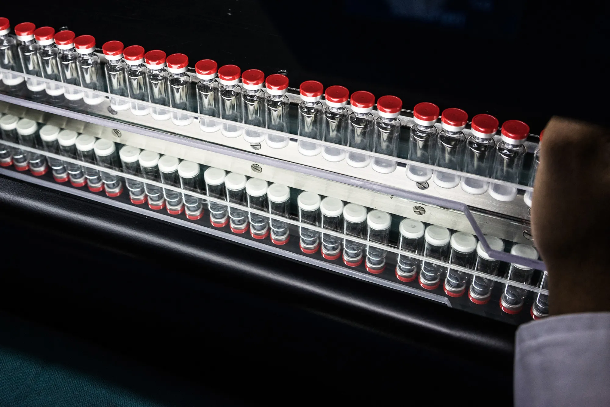 Vaccine vials move along the conveyor of a machine during inspection and screening for defects at the Serum Institute of India Ltd. pharmaceutical plant in Pune, Maharashtra, India, on Monday, May 4, 2015. Serum, Asia's largest vaccine maker, will look at a possible merger with generic drugmaker Cipla Ltd. if the European venture between the two companies succeeds.
