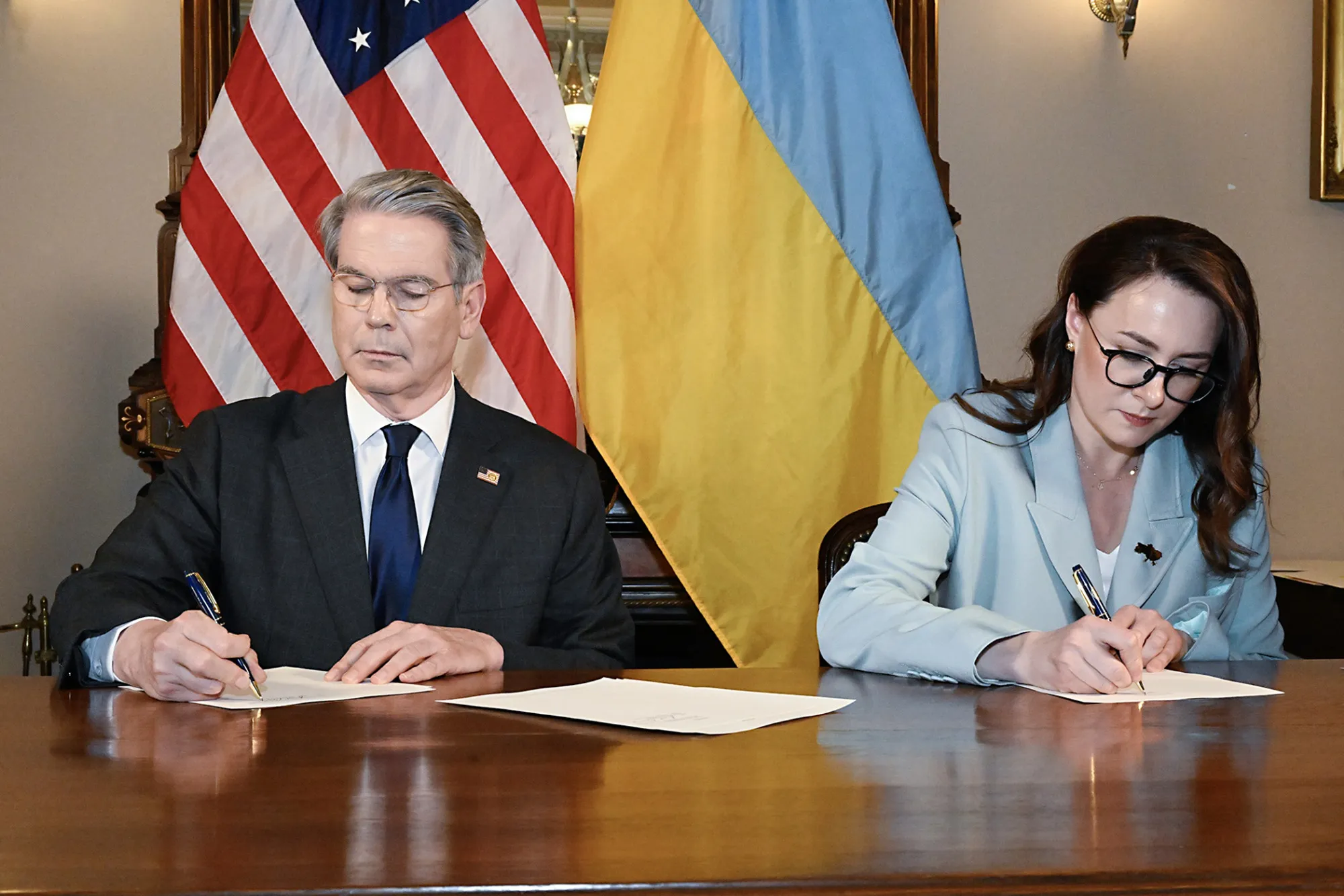 Scott Bessent and Yulia Svyrydenko sign the deal granting the US privileged access to develop Ukraine’s natural resources, in this photo supplied by US Treasury Department, on April 30.