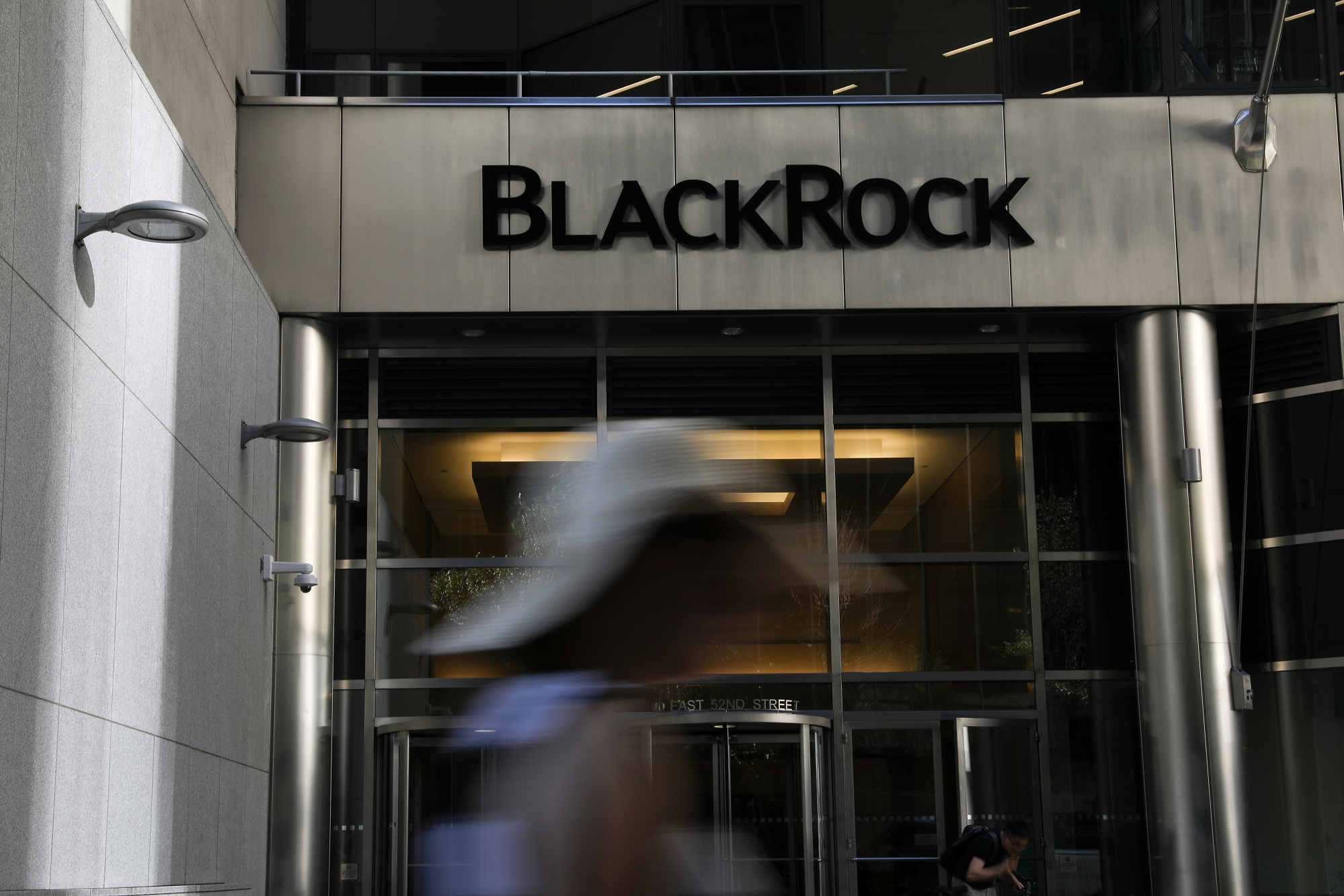 A pedestrian walks past BlackRock headquarters in New York.