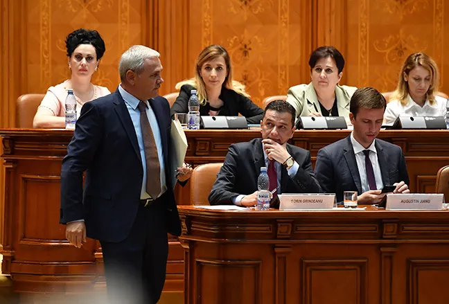 Romanian Prime Minister Sorin Grindeanu (C) looks at Liviu Dragnea (L), the president of the ruling Social Democrat party (PSD), as he prepares to address the Romanian Parliament during a no-confidence vote in Bucharest on June 21.
