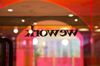 A colored glass wall is illuminated at the WeWork.