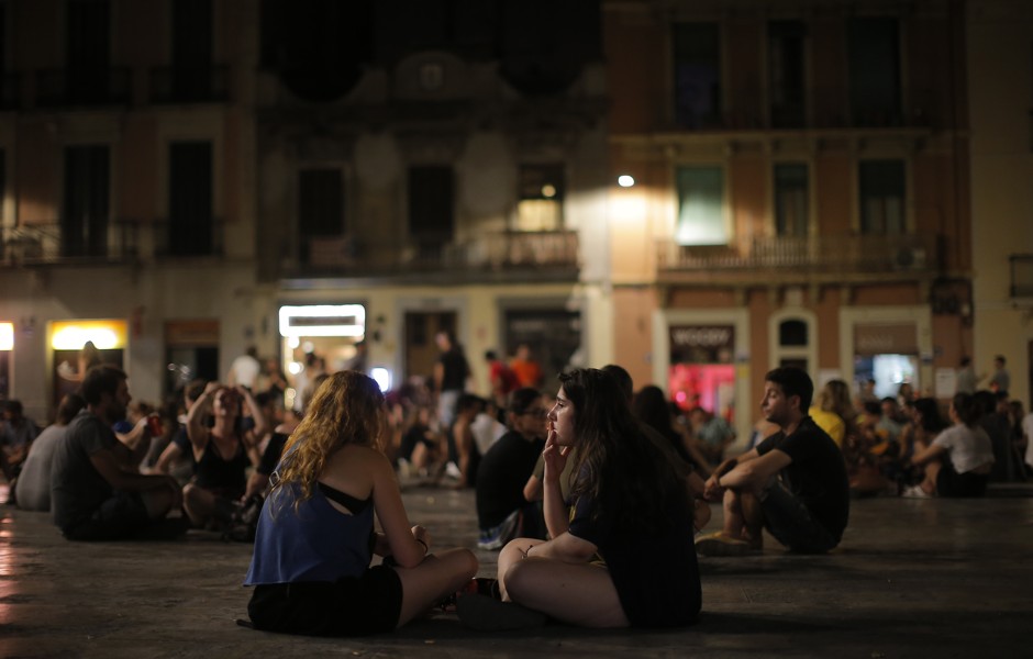 Young people in Barcelona's Gracia neighborhood, where streets remain busy until early morning throughout much of the week