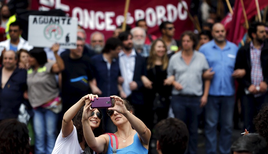 Two women take a selfie during a protest against economic policies in Buenos Aires, Argentina, December 22, 2015.