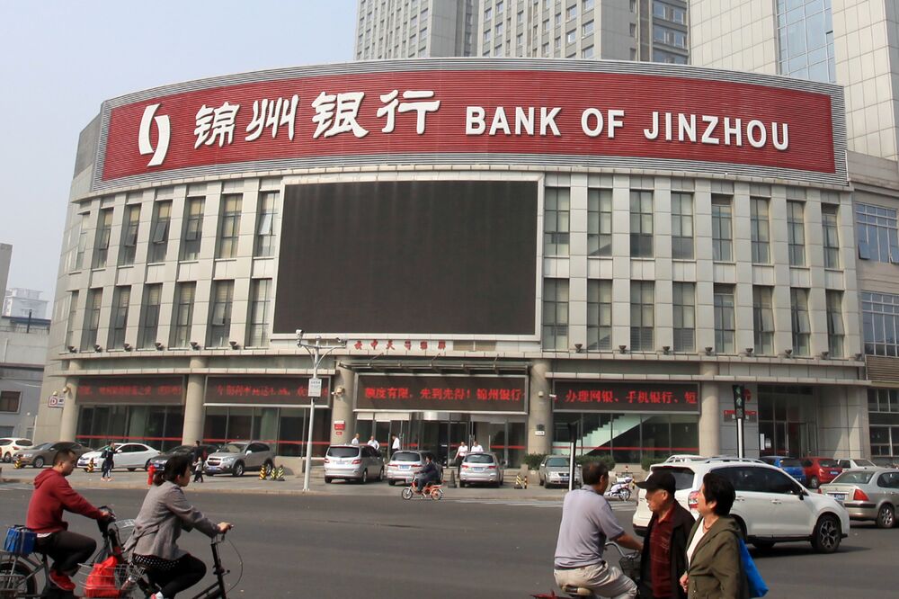 Pedestrians walk past a branch of Bank of Jinzhou in Tianjin city, China.