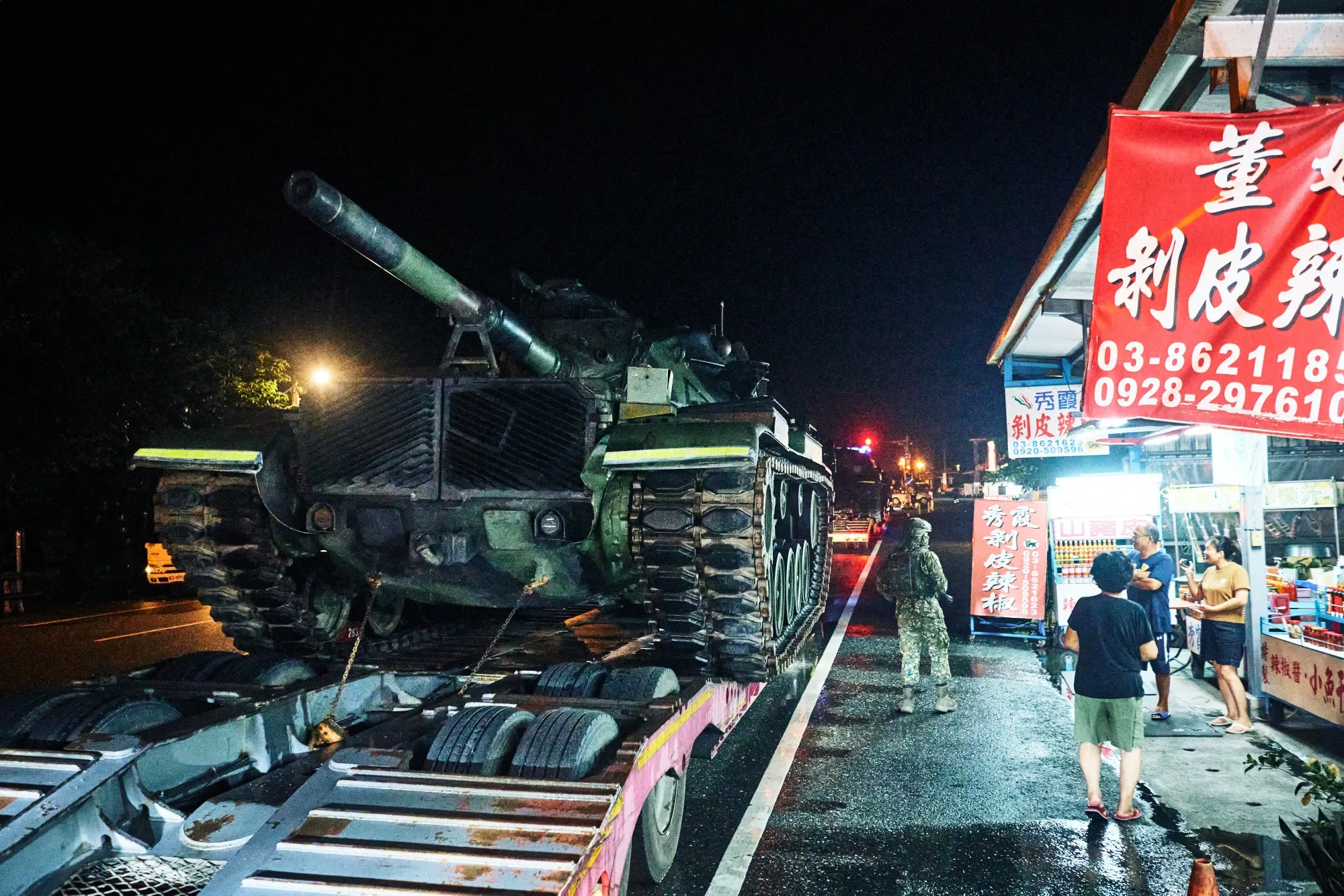 Civilians look on as private contractors transport military vehicles through Hualien on Taiwan’s east coast.