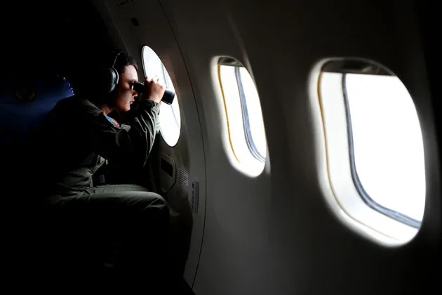 An Indonesian navy service member looks out before departing for a search operation to find AirAsia flight QZ8501 at the Indonesian Naval Aviation Base Juanda on Jan. 3, 2015, in Surabaya.