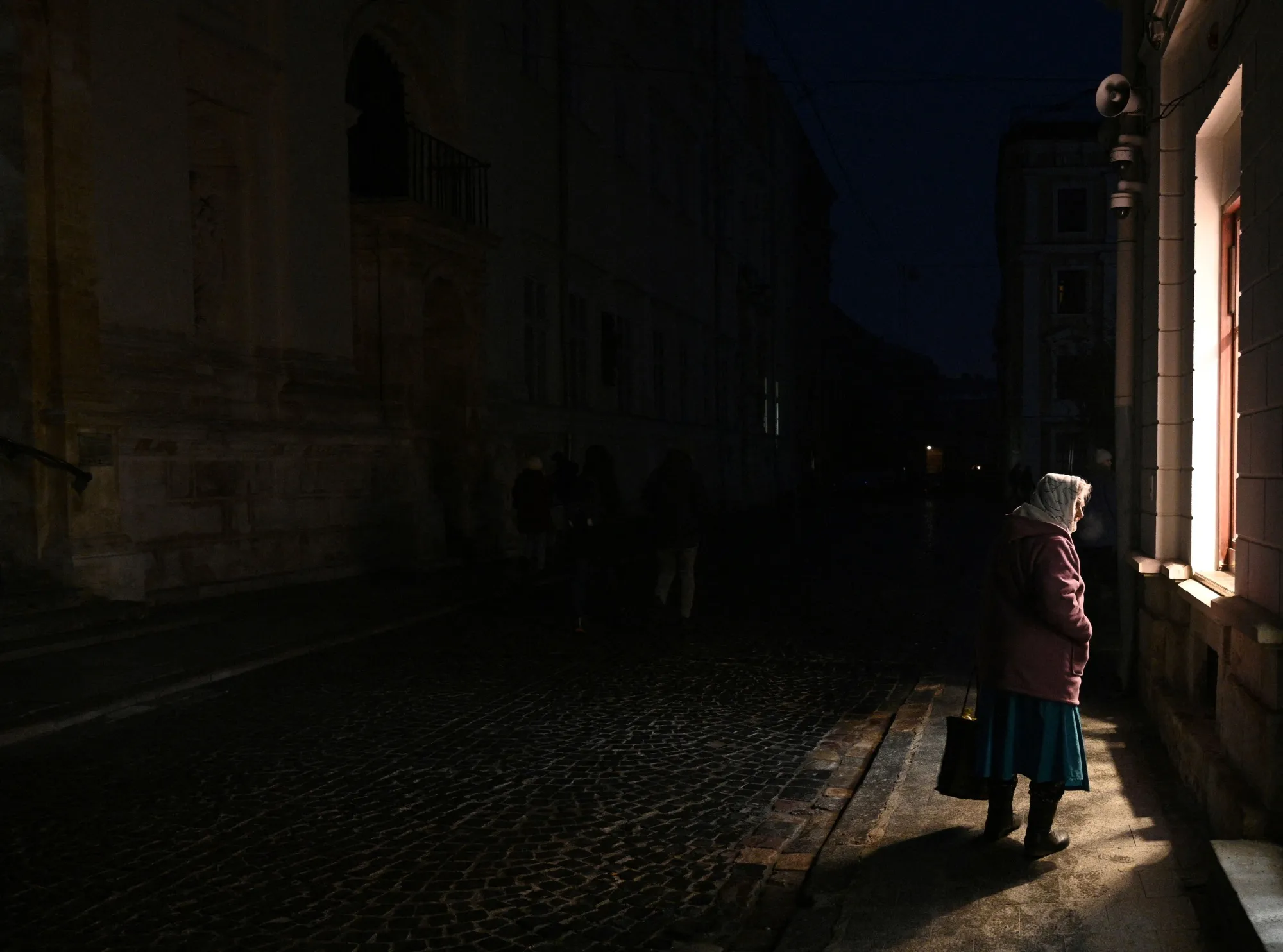 A woman walks on a street during a blackout&nbsp;in&nbsp;Lviv on November 23.&nbsp;
