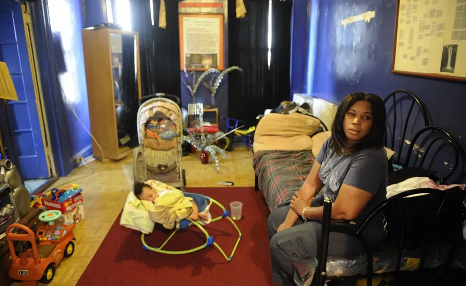 Michelle Echevarria sits with her baby in their Bronx apartment, which has a severe mold problem.