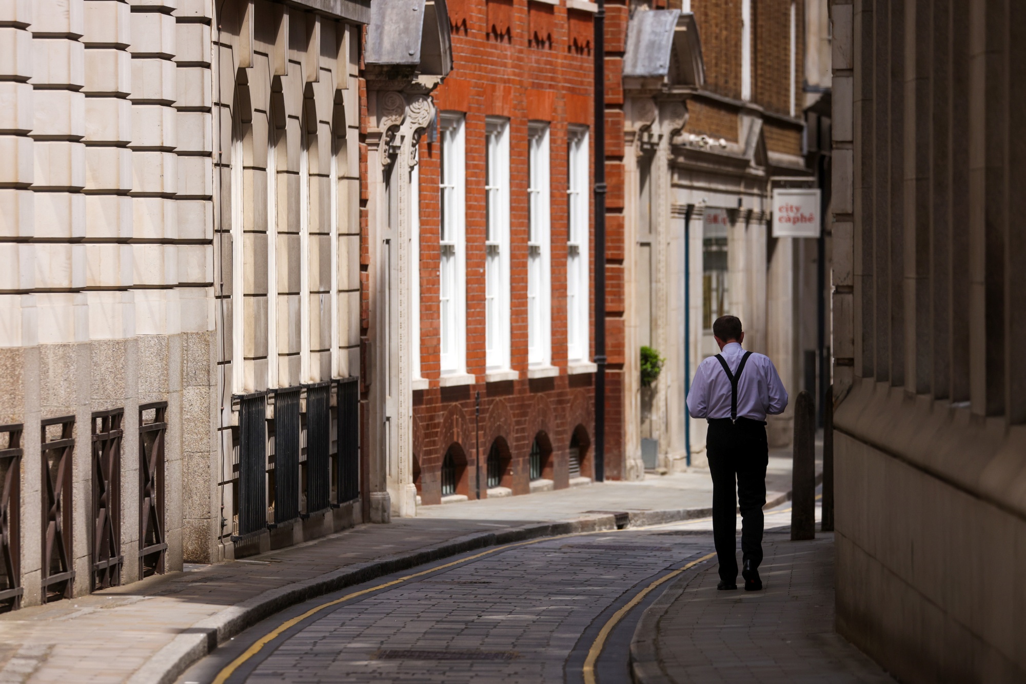 A pedestrian passes a restaurant in a narrow alley in the City of London, on June 7.