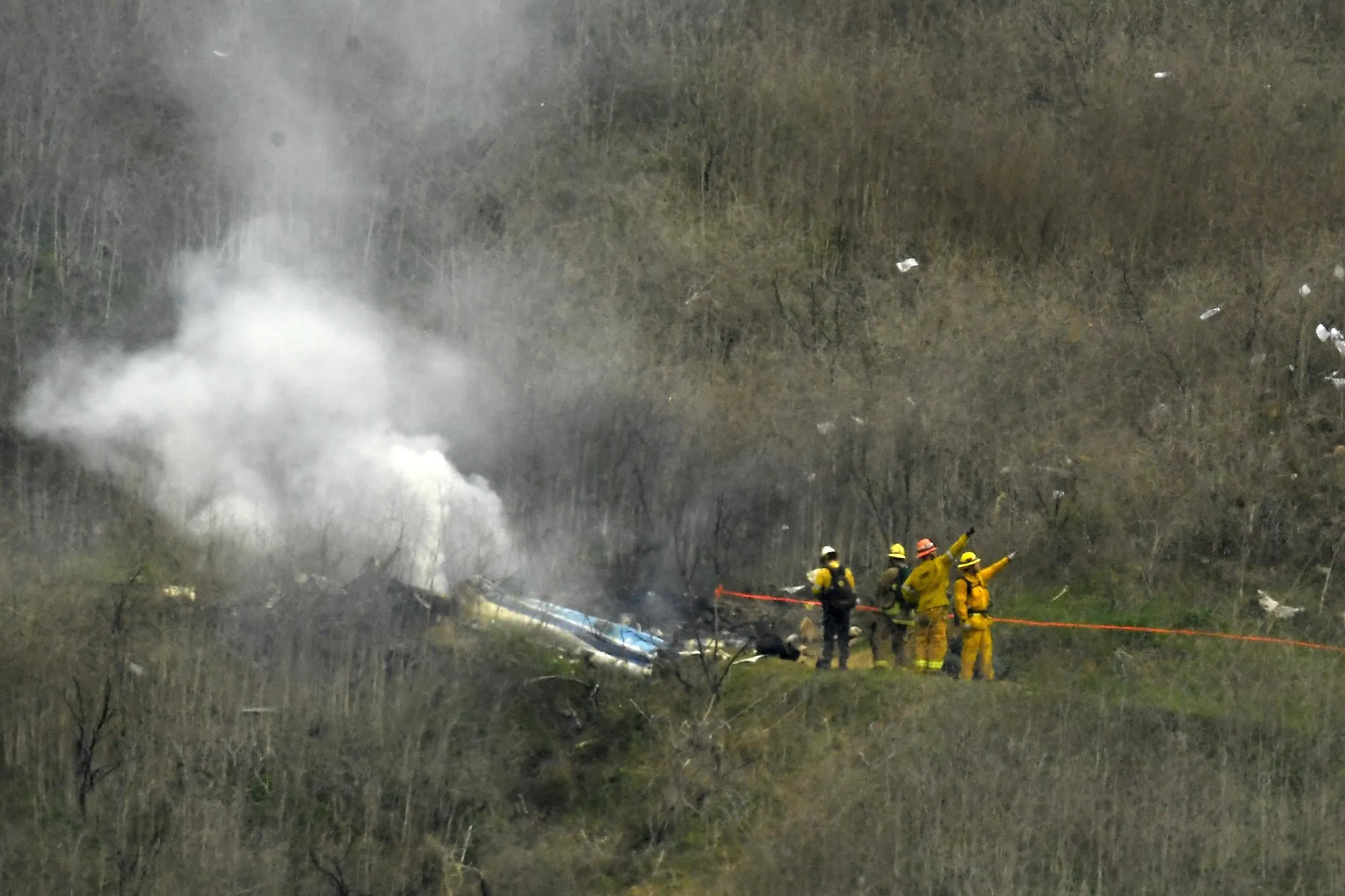 Firefighters work the scene of a helicopter crash where former NBA basketball star Kobe Bryant died in Calabasas, Calif., Jan. 26, 2020. Bryant's widow is taking her lawsuit against the Los Angeles County Sheriff's Department and Fire Department to a federal jury seeking compensation for photos deputies shared of the remains of the NBA star, his daughter and seven others killed in a helicopter crash in 2020. (AP Photo/Mark J. Terrill, File)