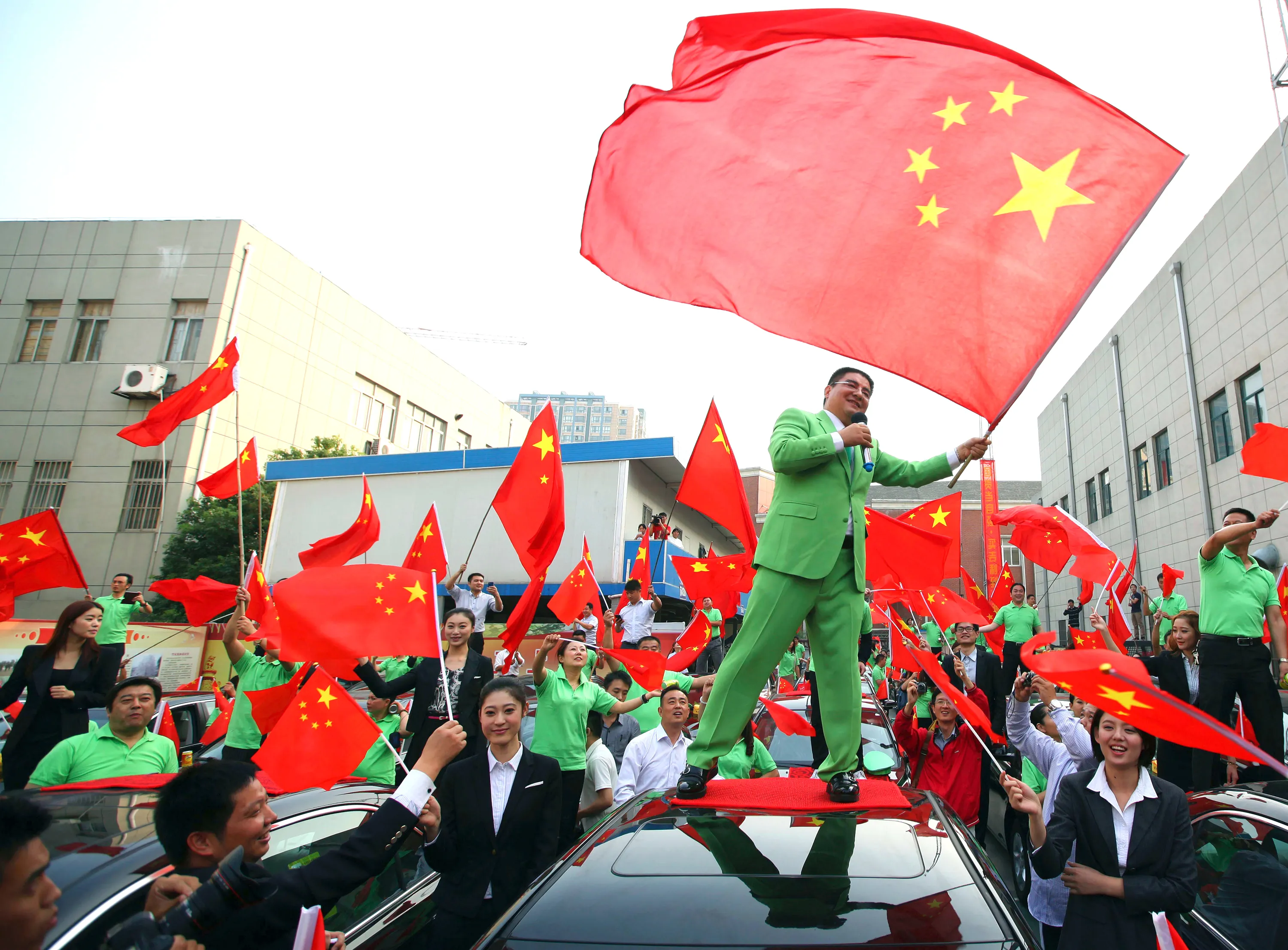 Chinese billionaire and philanthropist Chen Guangbiao offers Chinese cars to owners of Japanese cars damaged during anti-Japan protests in Nanjing, China on Oct. 10, 2012. Photographer: AP Photo