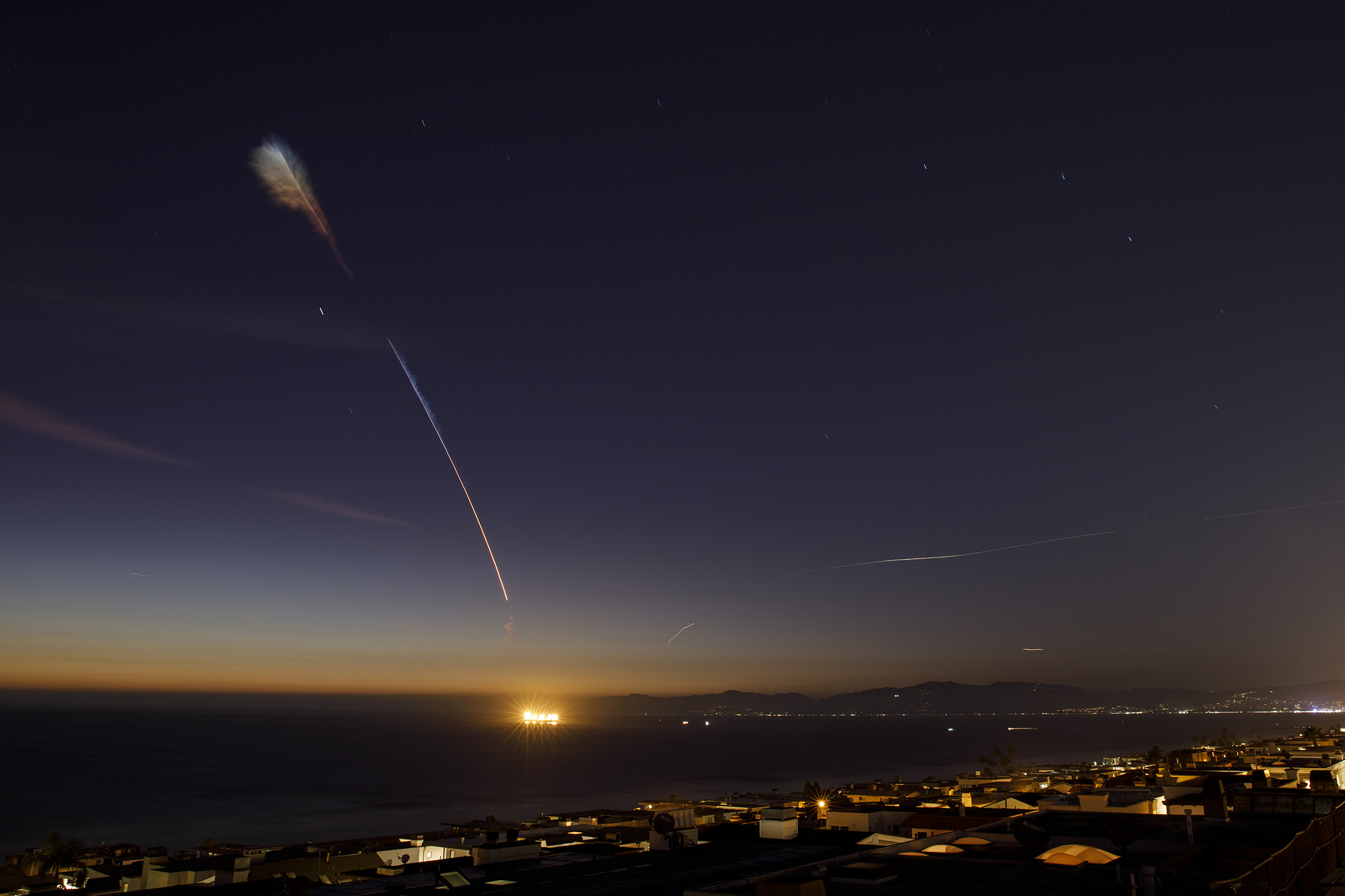 A SpaceX Falcon 9 rocket leaves a brightly covered streak at high altitude