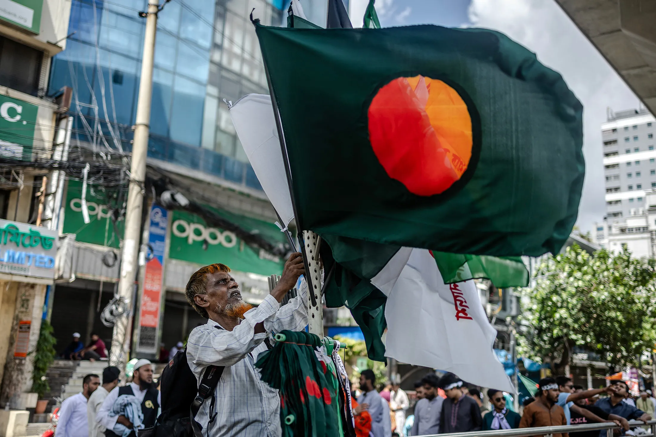 A man sells national flags along a street in Dhaka on Friday, a day after a new interim government was sworn in in Bangladesh.&nbsp;