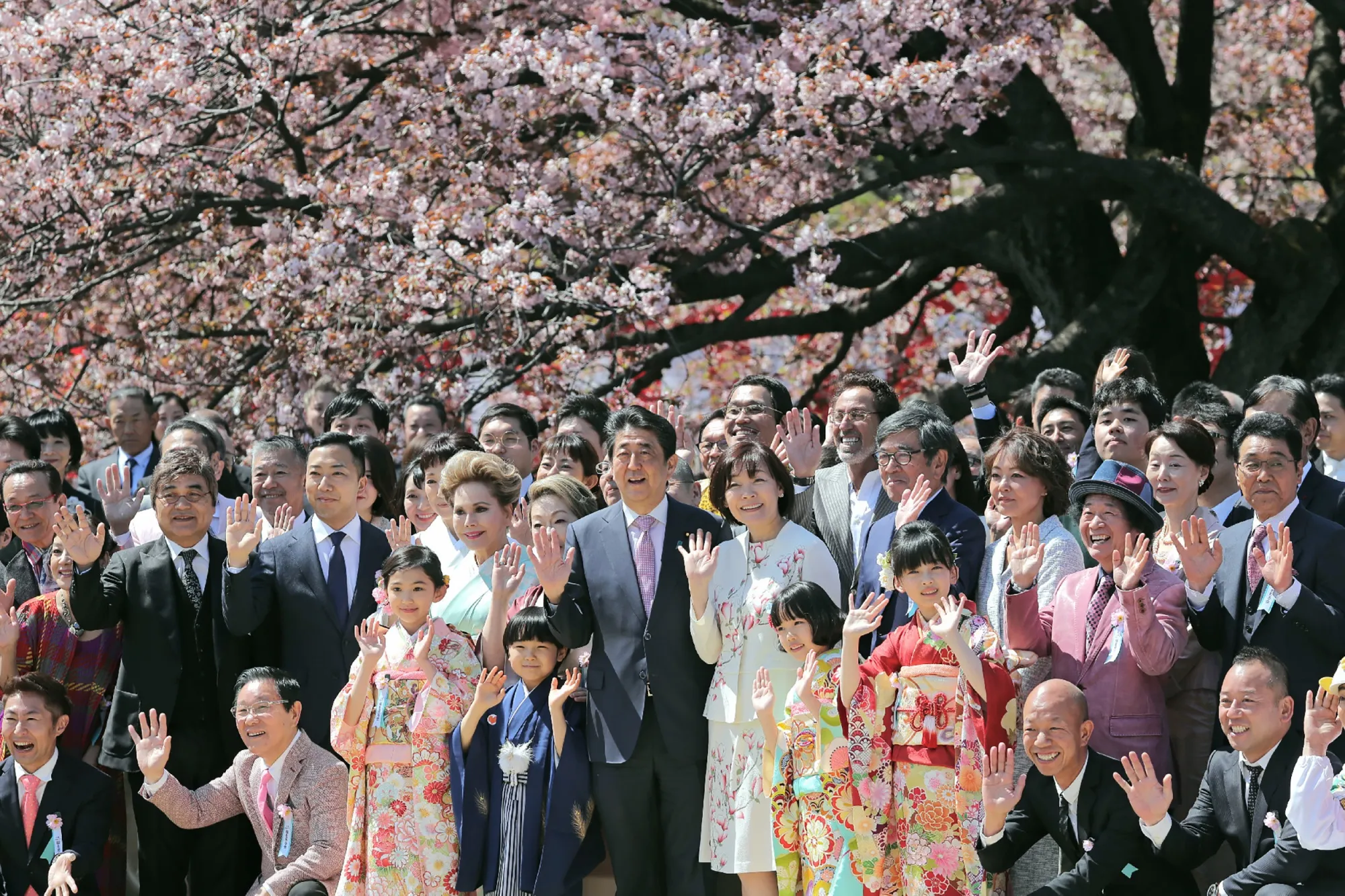Shinzo Abe and guests pose for pictures during his cherry blossom viewing party in Tokyo on April 13.