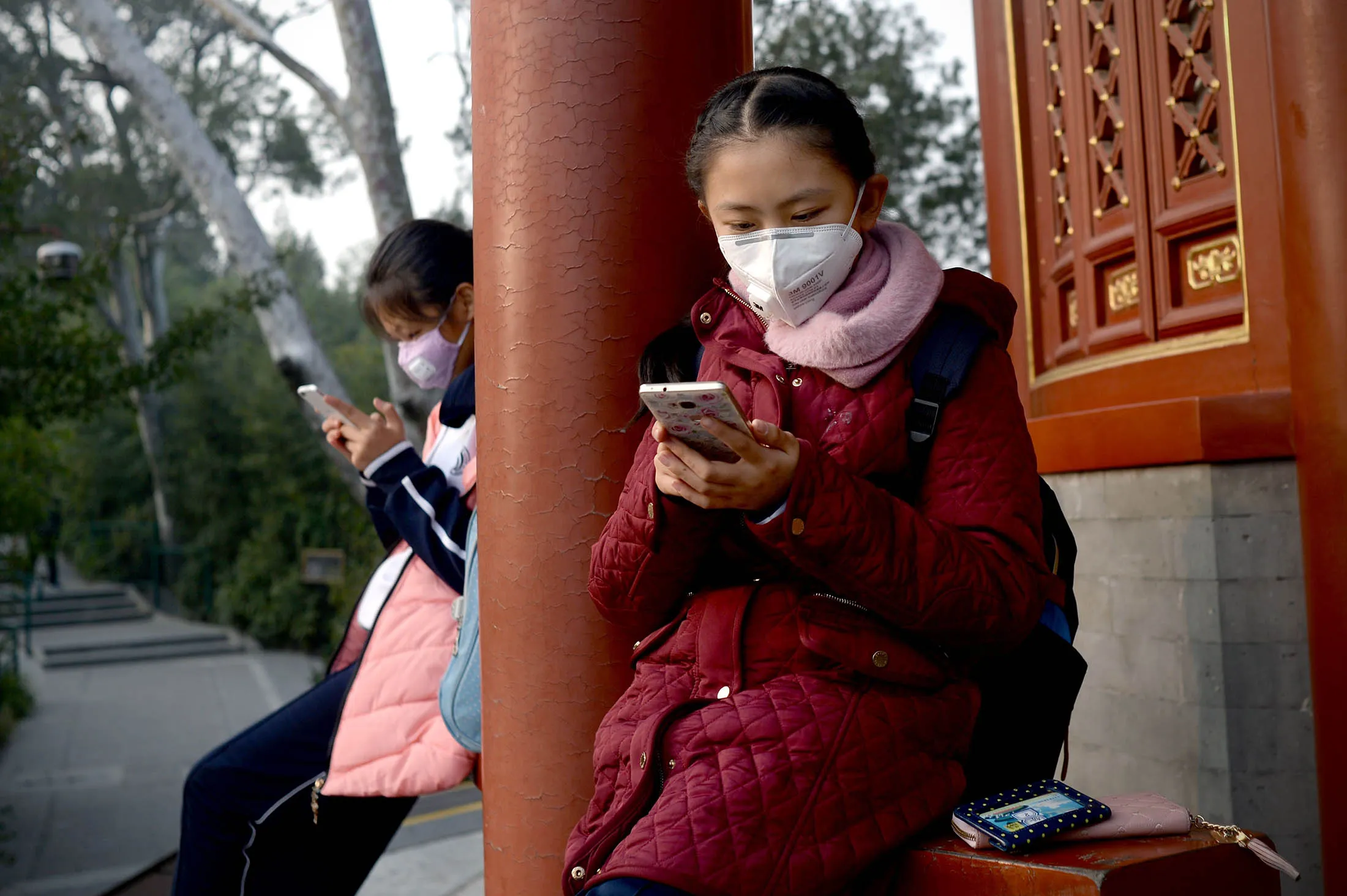 Two students look at their mobile phones in Beijing.
