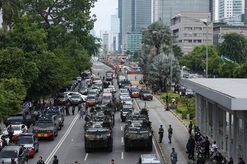 Armored police and military vehicles secure the explosion site.
