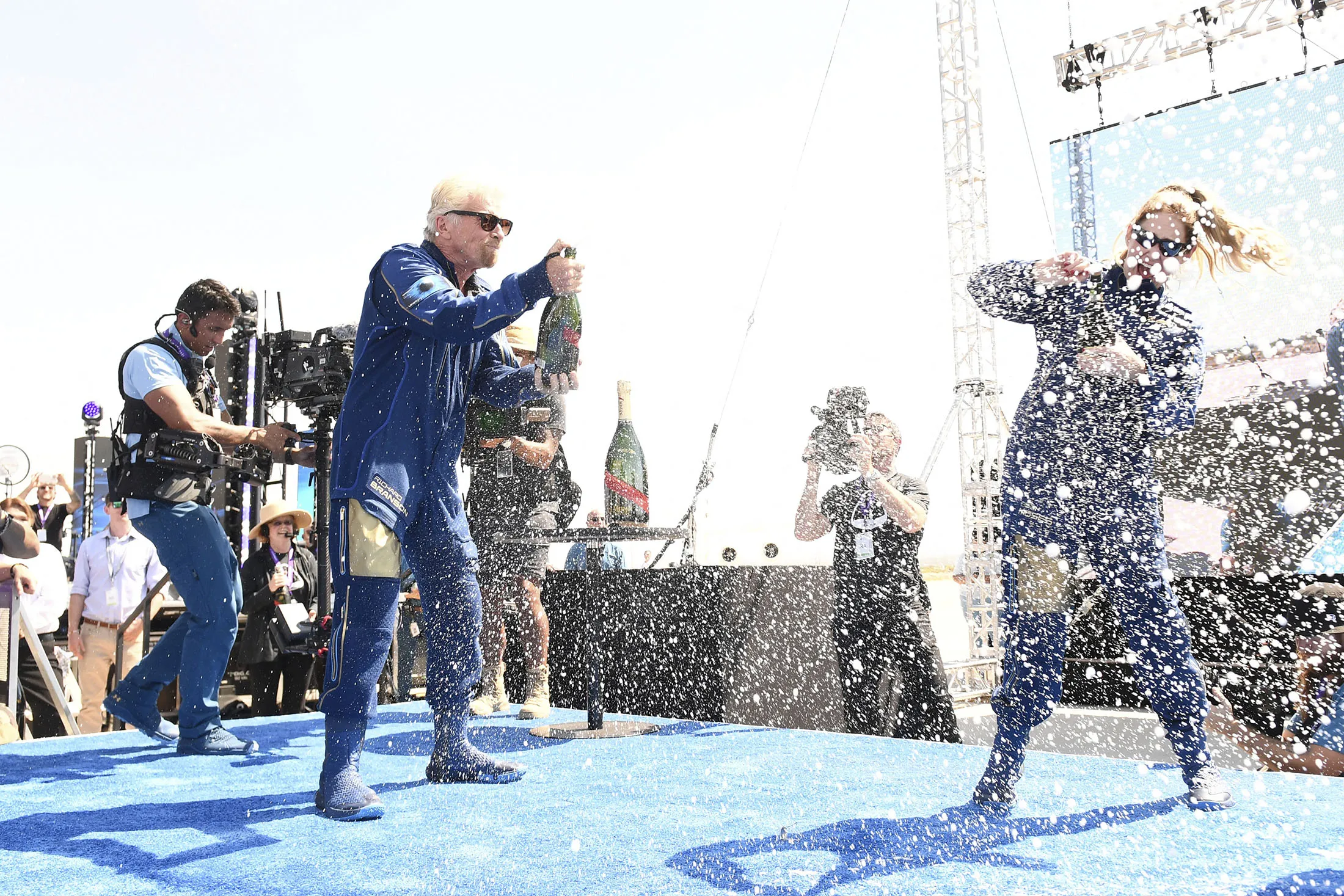 Billionaire Richard Branson, left, celebrated with champagne and other passengers after flying into space aboard Virgin Galactic’s VSS Unity on July 11.