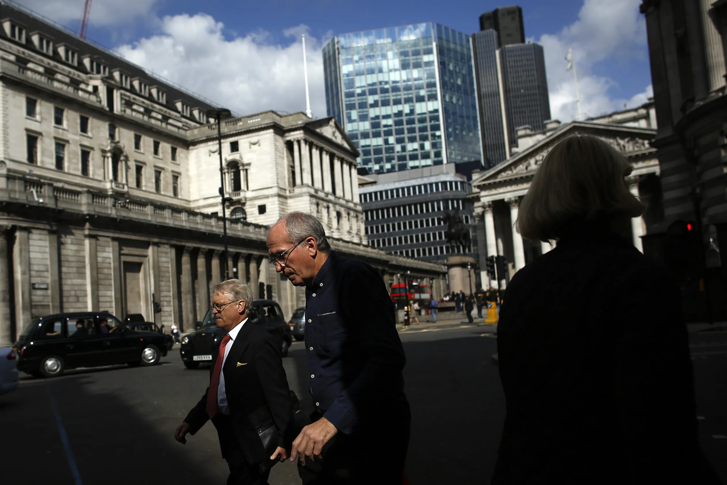 Pedestrians walk past the Bank of England in the City of London.