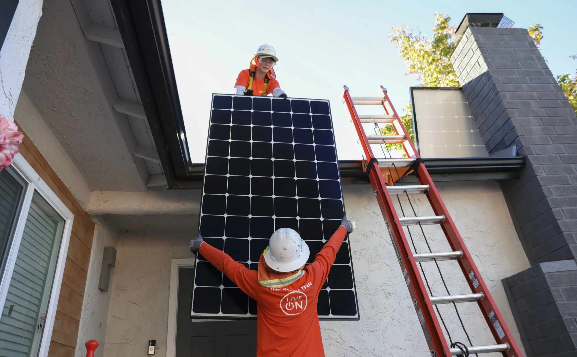 Workers install solar panels on the roof&nbsp;of a home in Poway, California, Dec. 5, 2023.&nbsp;